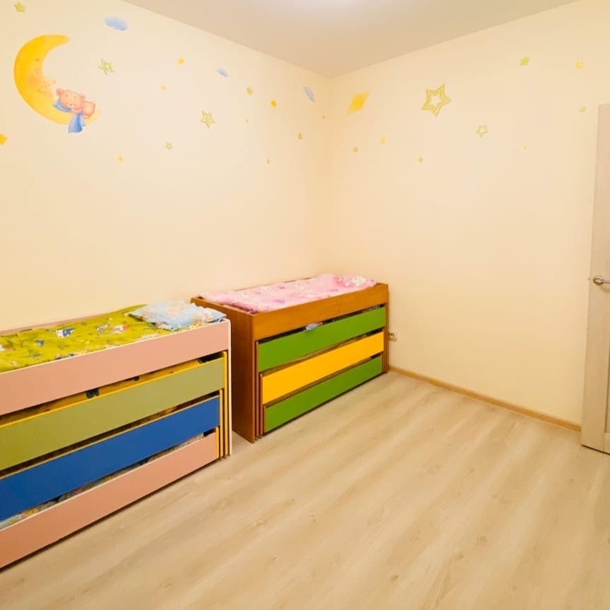 Детская спальня в платном детском садике домашнего типа 