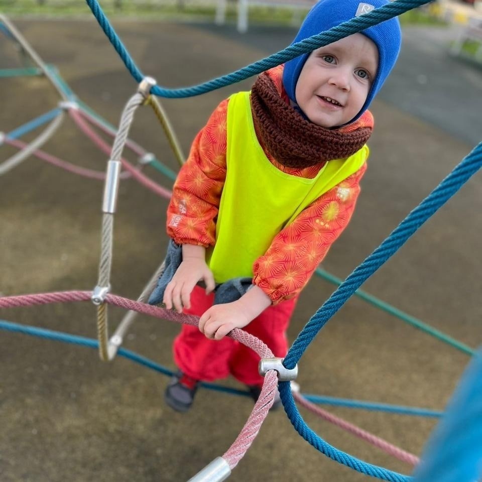 Ребёнок лазает на детской площадки детского сада Мими Дом 