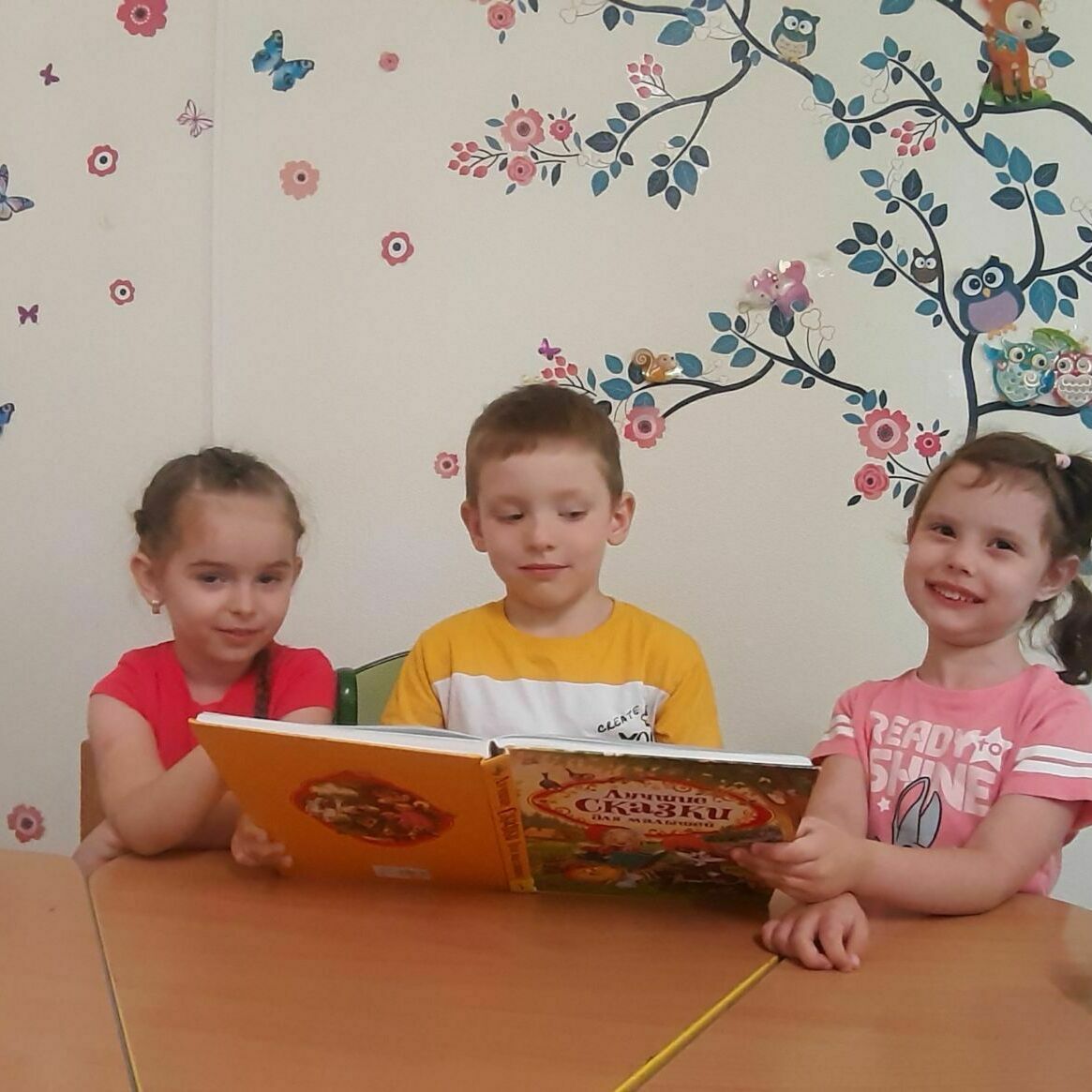 Садик в Петербурге – дети играют с книгой 